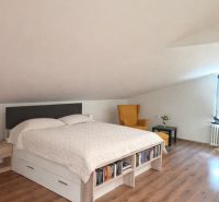 Veľký dom s veľkou garážou v Mankovciach  - Spálňa v rodinnom dome s podlahou s dreveným dekorom, posteľou a kreslom.