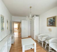 4- izbový byt s halou a lodžiou. - Obývačka so svetlým nábytkom v 4-izbovom byte a podlahou s dreveným dekorom.