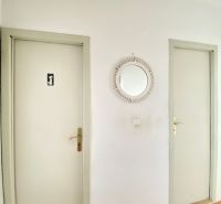4- izbový byt s halou a lodžiou. - Chodba v 4-izbovom byte s podlahou s dreveným dekorom a dvoma dverami.