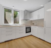 ,Prenájom moderný 3 izb. byt, Sološnícka ul,124 m2, Karlova Ves - Kuchyňa s bielymi skrinkami a podlahou s dreveným dekorom v rodinnom dome.
