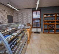 I Dom s wellness, bazénom a hotovým biznis potenciálom - Obchodný interiér s chladiacim pultom a regálmi na víno v rodinnom dome.