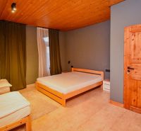 I Dom s wellness, bazénom a hotovým biznis potenciálom - Spálňa v rodinnom dome s drevenými posteľami a podlahou.
