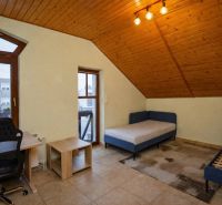 I Dom s wellness, bazénom a hotovým biznis potenciálom - Izba v rodinnom dome s posteľami, písacím stolom a dreveným stropom.