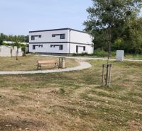 I Predaj 5-i mezonetu s vlastným pozemkom - Park s lavičkou a chodníkom, v pozadí budova v Dunajskom Klátove, 5 a viac izbový byt.