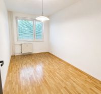Na prenájom priestranný 2-izbový byt s loggiou | Žilina – Hájik - Prázdna izba v 2-izbovom byte s podlahou s dreveným dekorom a bielymi stenami.