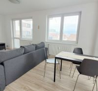 Pekný 2i byt, NOVOSTAVBA, PARKING, BALKÓN, KLÍMA, Jégého alej III. - Obývačka s pohovkou, televízorom a jedálenským stolom v 2-izbovom byte.