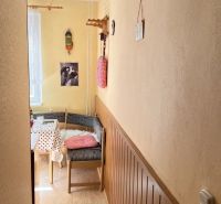 Príjemný 2-izbový byt na predaj – Utekáč - Útulný kútik v 2-izbovom byte s podlahou s dreveným dekorom a farebnými dekoráciami.