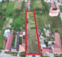 Stavebný pozemok 1 750 m² v centre obce Rumanová - Pozemok na bývanie v Rumanovej so zeleňou a okolitými domami.