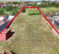 Stavebný pozemok 1 750 m² v centre obce Rumanová - Pozemky - bývanie v Rumanovej, vhodné pre stavbu, obklopené zeleňou a susednými domami.