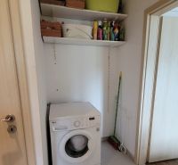 PRENÁJOM - 3-izbový svetlý byt - Teplická ulica, Bratislava - Práčka s dvoma policami s čistiacimi prostriedkami v práčovni 3-izbového bytu.