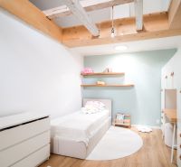 Dom medzi stromami: Nadčasová architektúra v Cabaj-Čápore - Detská izba v rodinnom dome s posteľou, skriňou a podlahou s dreveným dekorom.