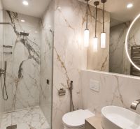 Diamant medzi apartmánmi v srdci Starého mesta - Kúpeľňa s mramorovými obkladmi v 2-izbovom byte, disponujúca veľkým zrkadlom a sprchovacím kútom.