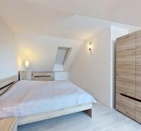 3 - izbový byt, veľkometrážny mezonet - 100 m2, Centrum, Senec - Spálňa s posteľou a skriňou s dreveným dekorom v 3-izbovom byte.
