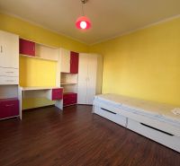 NOVINKA!!! Priestranný 3-izbový byt, 72 m² | Karpatská, Sásová - Detská izba v 3-izbovom byte so žltými stenami a nábytkom s úložným priestorom.