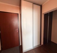 NOVINKA!!! Priestranný 3-izbový byt, 72 m² | Karpatská, Sásová - Predsieň v 3-izbovom byte s bielou šatníkovou skriňou a podlahou s dreveným dekorom.