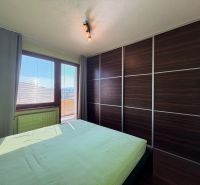 NOVINKA!!! Priestranný 3-izbový byt, 72 m² | Karpatská, Sásová - Spálňa v 3-izbovom byte s podlahou s dreveným dekorom a veľkou vstavanou skriňou.