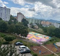 NA PREDAJ PRIESTRANNÝ 3-IZBOVÝ BYT | 67 m² | LODŽIA | 4. POSCHODIE - Pohľad na farebné ihrisko, ihrisko a paneláky na Mateja Bela v Trenčíne.