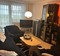 NA PREDAJ PRIESTRANNÝ 3-IZBOVÝ BYT | 67 m² | LODŽIA | 4. POSCHODIE - Obývacia izba v 3-izbovom byte s pohodlným posedením a stojatou lampou.