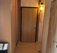 NA PREDAJ PRIESTRANNÝ 3-IZBOVÝ BYT | 67 m² | LODŽIA | 4. POSCHODIE - Chodba v 3-izbovom byte s podlahou s dreveným dekorom a stenovou lampou.