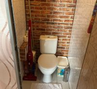 NA PREDAJ PRIESTRANNÝ 3-IZBOVÝ BYT | 67 m² | LODŽIA | 4. POSCHODIE - Kúpeľňa v 3-izbovom byte s toaletou, tehlovým vzorom a čistiacimi prostriedkami.