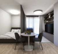REZERVOVAÝ 3 izbový na predaj Tomčany, 136 m2 poschodie 3 terasa 59 m2 - Interiér 3-izbového bytu s posteľou, jedálenským stolom a televíziou.