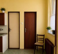 NA PREDAJ - Rodinný dom - Banská Bystrica - CENTRUM - Kuchyňa v rodinnom dome so žltými stenami, tmavohnedými dverami a radiátorom.