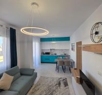 Albánsko, Durres - zariadený apartmán len 100m od mora a pláže - Obývacia izba 2-izbového bytu so štýlovým osvetlením, kuchyňou a pohodlnou sedačkou.