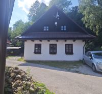 Predaj: Štýlová chalupa v srdci Španej Doliny miesto s atmosférou  - Chata v Španej Doline s bielou fasádou a satelitnou anténou, obklopená zeleňou.