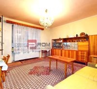 Veľkorysý rodinný dom s garážou | Piešťany - Obývacia izba v rodinnom dome s retro nábytkom a vzorovaným kobercom.