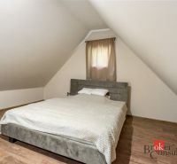 Chata na samote na predaj, Píla, Žarnovica - Podkrovná spálňa na chate s posteľou a podlahou s dreveným dekorom.