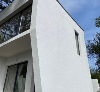 Vaša nová oáza pokoja s investičným potenciálom v Šahách - Chata v Šahách s výraznými preskleniami a bielou fasádou.