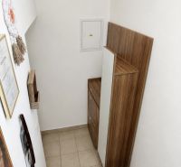 Krásny priestranný klimatizovaný 1izbový byt s terasou 66m2 - Schodisko s úložným priestorom v 1-izbovom byte, biela stena, drevený dekor.