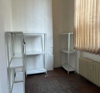 Na prenájom reprezentatívne nebytové priestory v centre mesta Lučenec - Kancelária s regálmi, radiátorom a závesmi, podlaha s dreveným dekorom.