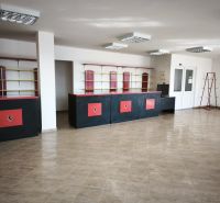 Prenájom obchodno-administratívneho priestoru , Šaľa  centrum - Obchodné priestory s dlažbou, čierne a červené pulty, police a regály.