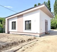 Novostavba moderného 4i rodinného domu v Štitároch - Exteriér rodinného domu v Štitároch s jednoduchou fasádou a oknami na svahovitom teréne.