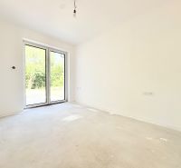 Novostavba moderného 4i rodinného domu v Štitároch - Prázdna izba v rodinnom dome s veľkým oknom a betónovou podlahou.