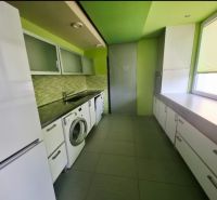 Prenajom moderného 3izb bytu na SNP ul - Kuchyňa v 3-izbovom byte s práčkou, bielym nábytkom a zelenými stenami.