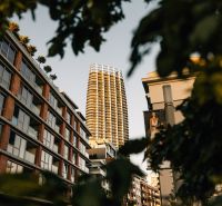 EUROVEA TOWER - Penthouse 4-izbový s výhľadom na downtown , 44.p - Výšková budova v pozadí ulice so zeleňou a bytovými jednotkami v Bratislave.