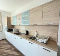 Na prenájom luxusný 3 izb. byt s garážou v Panorama City, Staré Mesto. - Kuchynská linka s bielymi skrinkami a podlahou s dreveným dekorom v 3-izbovom byte.