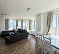 Na prenájom luxusný 3 izb. byt s garážou v Panorama City, Staré Mesto. - Svetlá obývacia izba s pohovkou a podlahou s dreveným dekorom, 3-izbový byt.
