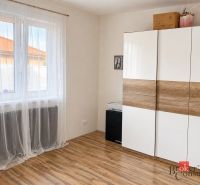 Predaj bungalovu - drevodom - Biela skriňa s dreveným dekorom a závesmi v izbe rodinného domu.