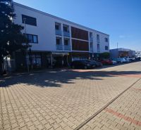 Moderný 2- izbový byt na prenájom , Rohožník - Budova na Senickej ulici v Rohožníku s parkovacími miestami v popredí.