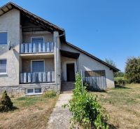 Na predaj dvojpodlažný rodinný dom v obci Kazimír, okres Trebišov - Rodinný dom na ulici Biela v Kazimíri, obklopený rozľahlou záhradou a modrou oblohou.