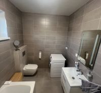 Rodinný dom - Alej Martina Benku - Kostolište  - Kúpeľňa v rodinnom dome s vaňou, umývadlom a práčkou, má keramické obklady.