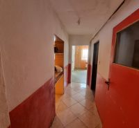 Dvojgeneračný rodinný dom s obrovským potenciálom v Šahách - Chodba v rodinnom dome s kachličkovou podlahou a červenými dverami.