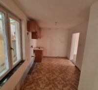 Dvojgeneračný rodinný dom s obrovským potenciálom v Šahách - Kuchyňa v rodinnom dome s oknom a podlahou s dreveným dekorom.