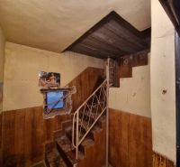 Dvojgeneračný rodinný dom s obrovským potenciálom v Šahách - Interiér rodinného domu s kovovým schodiskom, ošúchanými stenami a oknom s tapetou.