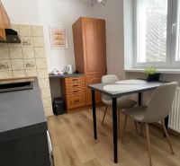 Prenájom 2-izbový byt s balkónom Martin – Podháj (41m2) - Kuchyňa v 2-izbovom byte s podlahou s dreveným dekorom a jedálenským stolom.