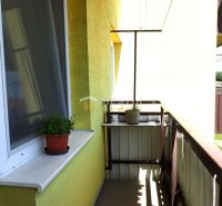 Veľkometrážny 3-izbový byt Smrdáky - Balkón v 3-izbovom byte s kvetináčmi a bielym parapetom.