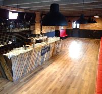 Reštaurácia s terasou na prenájom – centrum mesta - Obchodné priestory s barom a podlahou s dreveným dekorom, červené sedenie.